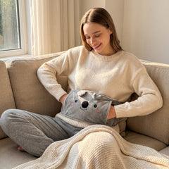 Mujer en el sofá con el cinturón de peluche koala puesto y las manos dentro